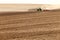 A Case International tractor pulling a plowing implement, plows an Idaho farm field