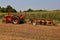 Case tractor hooked to a four bottom trip plow