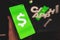 Cash App icon on phone with official website background
