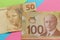 Cash bills from Canada and Brazil currency. Bills on colorful br