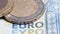 Cash coins and euro banknotes close-up. A bunch of euro coins on banknotes macro