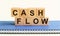 Cash Flow - text on wooden cubes on a white gradient background