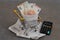 Cash receipts with euro banknotes in a supermarket trolley and a calculator close-up on a gray background