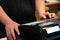 cash register installed on counter for accepting order from customer.sales man entering amount on electronic cash register in