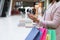 Cashback Bonus. Woman With Shopper Bags Using Smartphone In Mall After Shopping