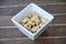 Cashew nuts inside white bowl on wood