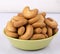 Cashew shape kaju biscuit image in green bowl