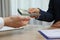 Cashier giving money to businessman at desk in bank