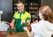 Cashier in retail store serving client