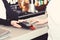 Cashiers hand holds credit card terminal on defocused background