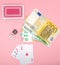 Casino, gambling and fortune concept. Game bones and cards and euro money on pink background with copy space