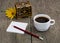 Casket, coffee, pencil with paper and a yellow flower