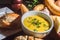 Cassava broth in a white bowl, ingredients on the side, copy space and dark background