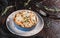 Casserole with cheese, broccoli, cauliflower and herbs in bowl over dark background with napkin. Healthy dinner or lunch setting,