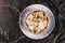 Casserole with cheese, broccoli, cauliflower and herbs in bowl over dark background with napkin. Healthy dinner or lunch setting