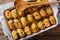 Casserole of Tater Tots with cheese and herbs close up in a baking dish. Horizontal top view