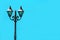 Cast iron antique lamppost against vibrant sky blue colored concrete wall