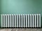 Cast iron batteries in a public building. Old heating radiators on the wall. Radiator sections in the room