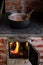 Cast iron cauldron boiling a goulash stew over a wood burning stove made from red bricks in the backyard of a rural house in