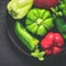 Cast-iron dish with different red and green bell peppers With drops of water