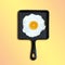 Cast-iron frying pan with fried eggs, slice of orange instead of