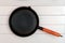 A cast iron frying pan over the background of whiteboards