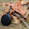 Cast iron pan against pile of wood