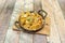 Cast iron pie pan with serving of Mexican corn nachos with guacamole, chopped red onion, sliced jalapenos, cheddar cheese and