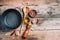 Cast iron pot, spices, pepper shaker, meat fork, oil, spices on wooden background. Top view. Copy space. Healthy, clean food and