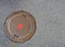 Cast-iron sewer cover with red point