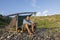 Castaway sitting at simple camp in morning light