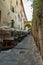 CASTIGLIONE DELLA PESCAIA, ITALY - SEPTEMBER 30, 2016: narrow street in hill with restaurant seats behind fortification wall