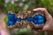 Casting blue epoxy resin burl wood cube in hand on old blurred background