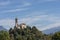 Castle on the hill landscape, mountains and peaks in background.