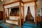 Castle interior bedroom, Secession art nouveau style, wood carved white canopy bed, sofa and stucco on the ceiling, renaissance