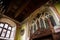 Castle interior, colored plaster, wall painting, gothic carved furniture, coat of arms, window with stained glass, grand hall of