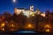 Castle Loket in winter, long night exposure with beautiful blue sky and yellow street christmas city lights with view on river