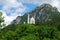 Castle Neuschwanstein in mountain forest, Alps