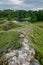 Castle ruins abandoned in the infinite beauty of the expansive green with river view.