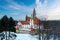 Castle in winter. Romantic fairytale castle in picturesque highland landscape, covered in snow. Castle with white church, high