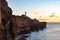 Castlepoint lighthouse standing on huge rugged cliffs above the ocean during orange sunset
