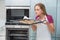 Casual attractive woman smelling baking tray with cookies