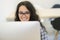 Casual caucasian businesswoman at business startup office with computer, wearing glasses.