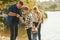 In casual clothes. Father and mother with son and daughter on fishing together outdoors at summertime