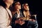 In casual clothes. Group of kids sitting in cinema and watching movie together