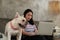 Casual freelance Asian cute woman working from home with her dog