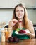 Casual girl in green eating boiled beets