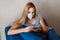 Casual girl in a protective face mask is phoning on labor issues. Isolated at home due to coronavirus epidemic of covid-19 and