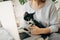 Casual girl working on laptop with her cat, sitting together in modern room with pillows and plants. Home office. Cute cat helping