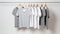 Casual white and grey t-shirts on a rod. Striped and plain casual clothes on wooden hangers. Generative AI